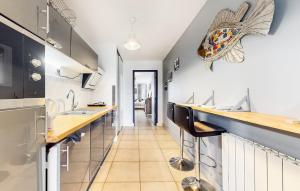 a kitchen with two sinks and a counter with a fish on the wall at STUDIO 88 in Sainte-Adresse