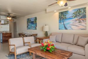 a living room with a couch and a table with flowers on it at Mana Kai 611C in Wailea