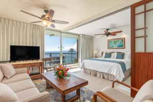 a bedroom with a bed and a tv and a balcony at Mana Kai 611C in Wailea