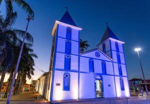 a church is lit up at night at Suíte Santa Luzia casal 03 in Trindade