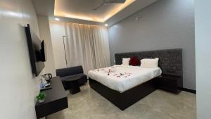 a hotel room with a bed and a table and a chair at Status Club in Hardoī