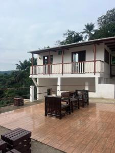 a building with wooden tables and benches on a deck at Resort Ideal Forest in São Tomé