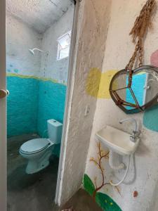 a bathroom with a toilet and a sink at Hostel Flor da Vida in Canoa Quebrada
