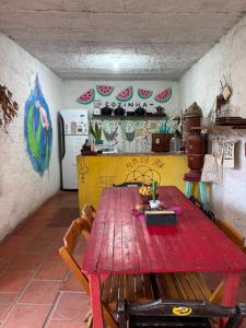 a kitchen with a wooden table in a room at Hostel Flor da Vida in Canoa Quebrada