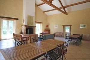 a room with tables and chairs and a fireplace at La métairie in Isle