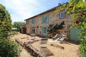 a house with two lawn chairs in front of it at La métairie in Isle
