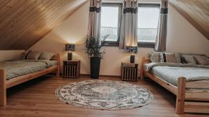 ein Dachzimmer mit zwei Betten und einem Teppich in der Unterkunft Bliżej do nieba in Istebna
