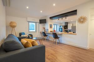 a living room with a couch and a kitchen at L'Appart de Rohan - Centre de Pontivy in Pontivy