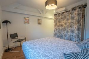 a bedroom with a blue bed and a desk at L'Appart de Rohan - Centre de Pontivy in Pontivy +4 photos