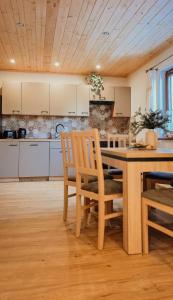eine Küche mit einem Holztisch und Stühlen in der Unterkunft Bliżej do nieba in Istebna