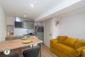 a living room with a yellow couch and a kitchen at Gîte la Planta de Cossey 2 in Claix