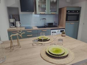 a kitchen with a table with two plates and wine glasses at Gîte la Planta de Cossey 2 in Claix