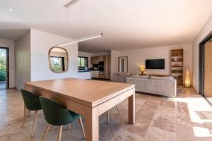 a dining room and living room with a table and chairs at Villa U Capu - Piscine Privée in Lecci
