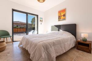 a bedroom with a large bed and a sliding glass door at Villa U Capu - Piscine Privée in Lecci +17 photos