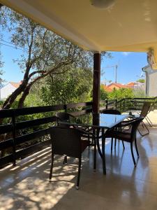 a patio with a table and chairs on a balcony at Apartmani Zora in Cres