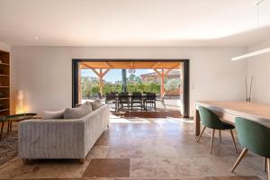 a living room with a couch and a table at Villa U Capu - Piscine Privée in Lecci