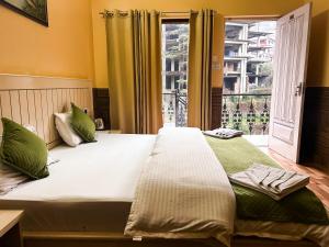 a bedroom with a large bed with a large window at Vacation home in Dharmsāla