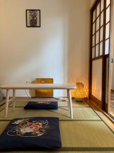 a table and a chair in a room at 青梅森の宿 in Ome