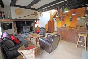 a living room with leather furniture and a fireplace at Le chat qui pêche in Rilhac-Rancon