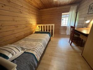 a bedroom in a log cabin with a bed and a desk at Le chat qui pêche in Rilhac-Rancon