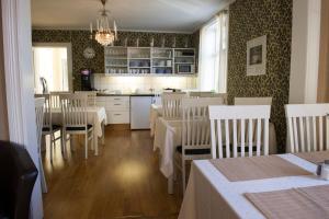 a dining room with tables and chairs and a kitchen at Lilla Hotellet i Nora in Nora