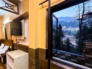 a room with a large window with a view at Vacation home in Dharmsāla
