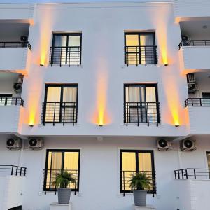 a white building with windows and potted plants at Arsuz Suit in Hatay