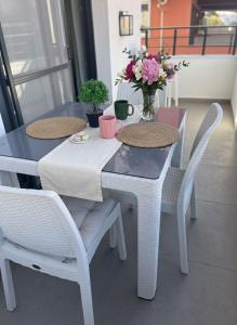 a table with two chairs and a vase of flowers on it at Arsuz Suit in Hatay +6 photos