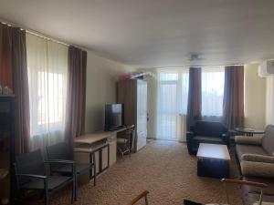 a living room with a couch and a tv at Apartments complex Breeze Sunny beach - Апартаменти комплекс Бриз Слънчев бряг in Sunny Beach