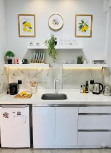 a kitchen with white cabinets and a sink at Arsuz Suit in Hatay