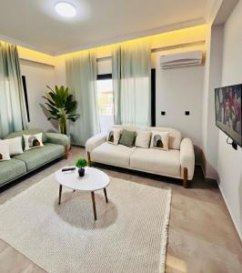 a living room with two couches and a table at Arsuz Suit in Hatay
