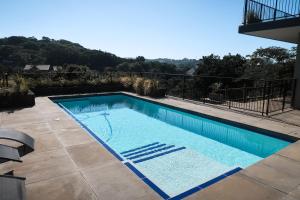 a large swimming pool in a yard with at Parrotfish Room in Ballito