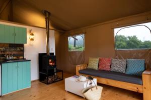 a living room with a couch and a stove at AfriCamps at White Elephant Safaris in Pongola Game Reserve +24 photos