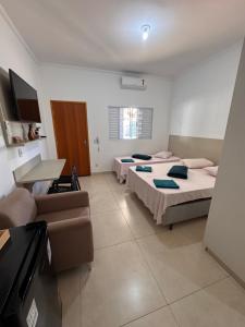 a living room with two beds and a couch at Vaz Lobo Kitnets in Mococa