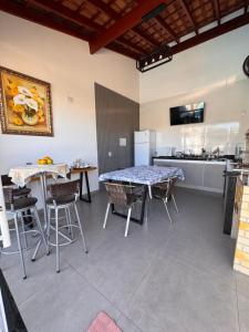 a kitchen with tables and chairs in a room at Vaz Lobo Kitnets in Mococa