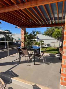 a patio with a table and chairs under awning at Vaz Lobo Kitnets in Mococa
