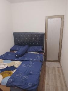 a bed with blue pillows sitting next to a door at Widodaren homestay singel bed in Ngadisari +4 photos