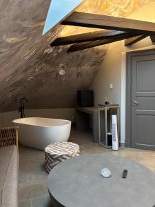 a living room with a bath tub and a table at Hotell Visby Börs in Visby