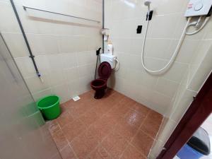 a bathroom with a toilet and a green bucket at Pangkor Homestay in Pangkor +60 photos