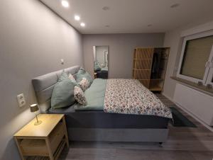 a small bedroom with a bed and a table at Sonnenschein & Ruhe in Losheim