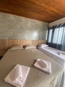 a bedroom with two white towels on a bed at Suítes Taipu de Fora in Marau +41 photos