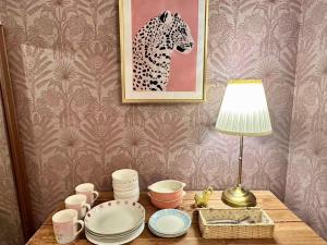a table with plates and a lamp and a picture at Mori de house in kobe 1 in Kobe