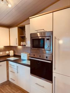 a kitchen with a stove and a microwave at Looby Lodge in Tattershall