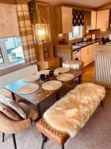 a dining room with a table with fur cushioned chairs at Looby Lodge in Tattershall
