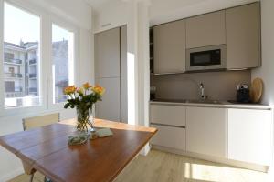 a kitchen with a wooden table with a vase of flowers on it at LA FORESTERIA Case a Varese in Varese +13 photos
