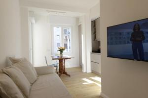 a living room with a white couch and a flat screen tv at LA FORESTERIA Case a Varese in Varese
