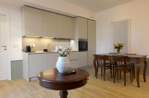 a kitchen and a table with a vase of flowers on a table at LA FORESTERIA Case a Varese in Varese