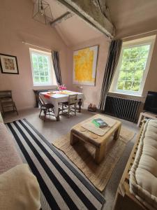 a living room with a table and a couch at Little Plas in Crickhowell