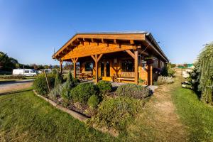 a wooden pavilion with a table and benches in a field at Resort Radslavice in Přerov