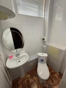 a bathroom with a white toilet and a sink at The Skyline Apartments in Samarkand